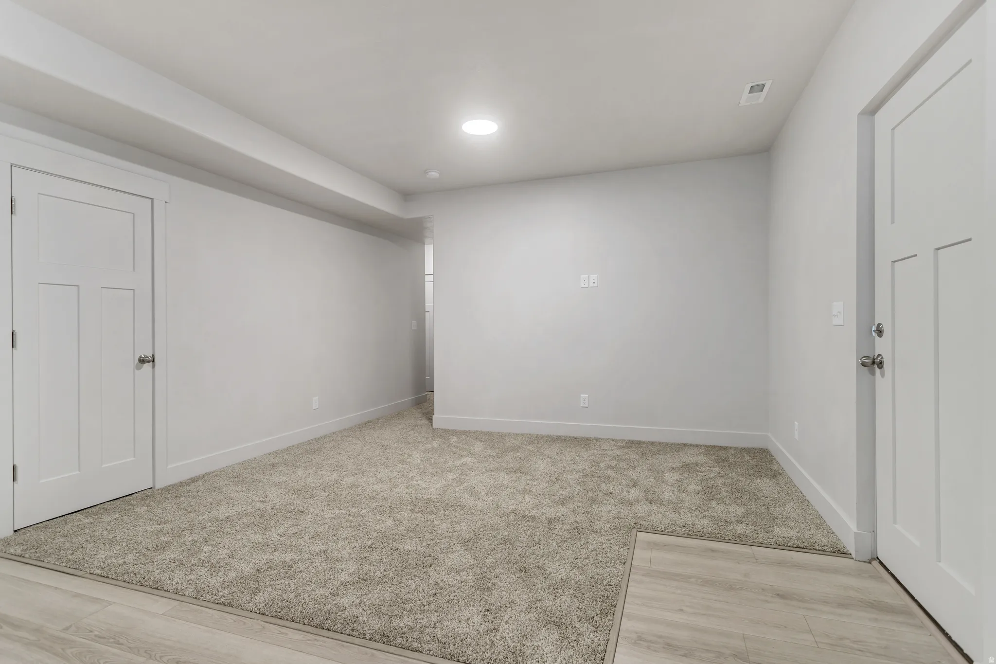 Carpeted living area with recessed lighting, light gray wall paint, and wood-finish flooring