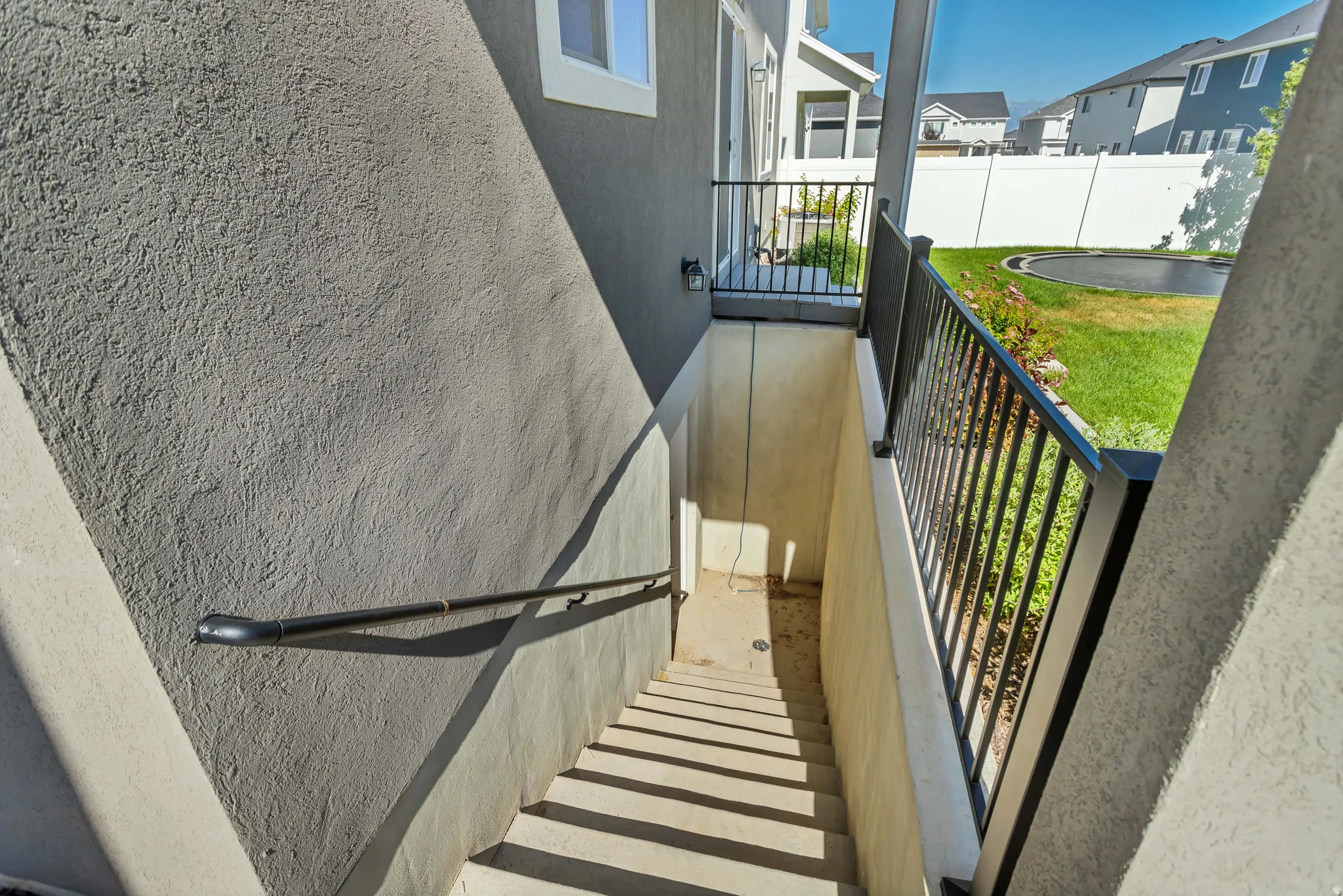 Concrete exterior stairway with metal railings and a metal handrail