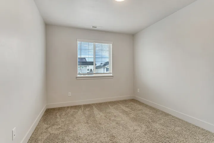 Plush carpet flooring, neutral paint palette, window with blinds, and recessed ceiling lighting
