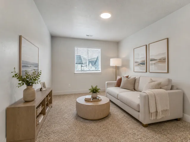 Recessed ceiling light, textured carpeting, window with horizontal blinds, light-toned walls, wood-finish console