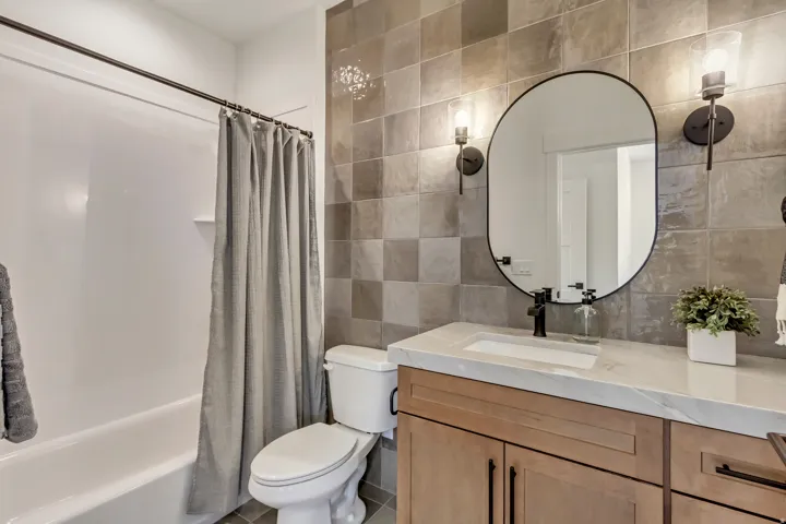 Wall-mounted vanity with wood-finish cabinetry, a rectangular undermount sink, and a light-toned countertop