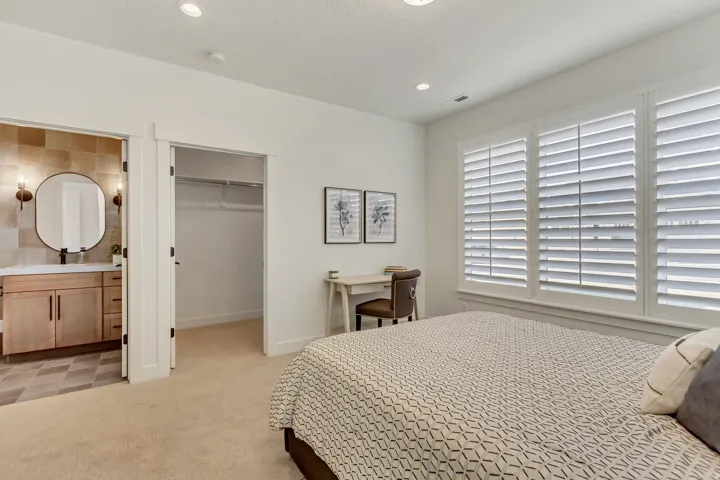 Bedroom featuring recessed lighting, a built-in closet with shelving, and window shutters