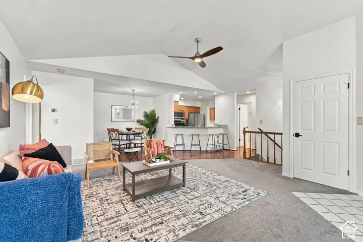 Vaulted ceiling, ceiling fan, wood-finish flooring, white paneled door, wood railing