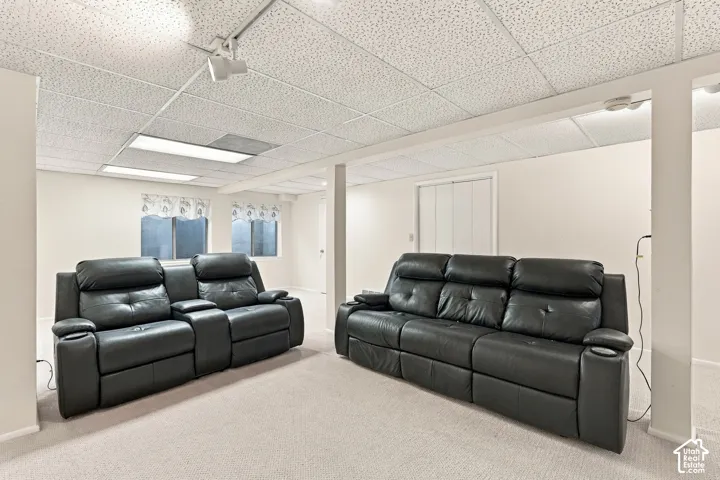Carpeted flooring, drop ceiling with recessed lighting, and painted walls