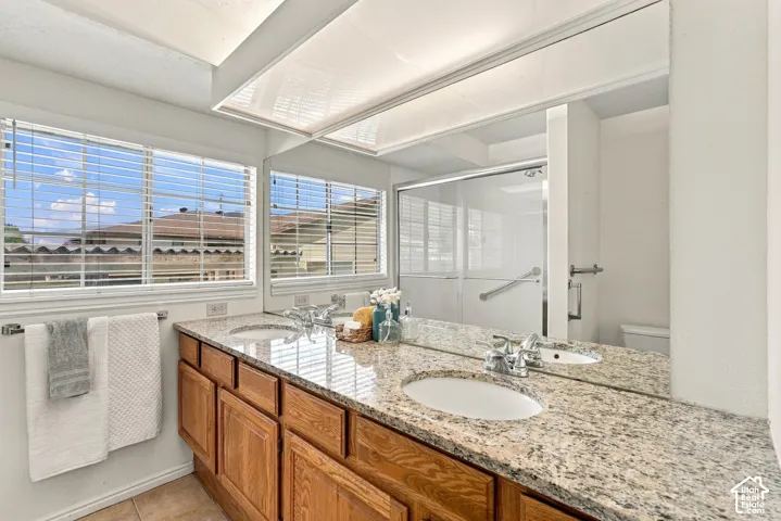 Dual vanity with undermount sinks, granite-style countertop, and wood-finish cabinetry