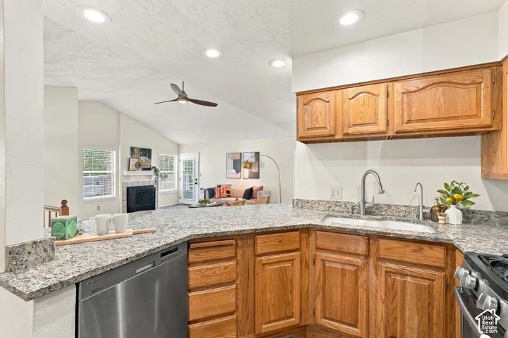 Kitchen featuring granite countertops, wood cabinetry, and a stainless steel dishwasher