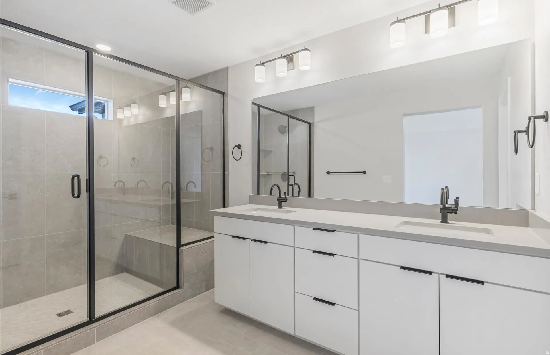 Expansive walk-in shower with glass enclosure and built-in bench