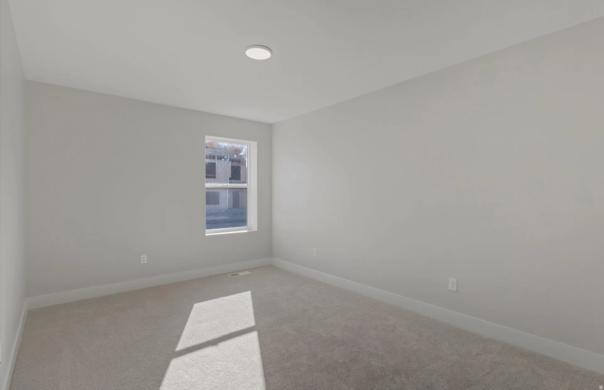 Recessed ceiling light, neutral wall tones, single window, and carpeted flooring