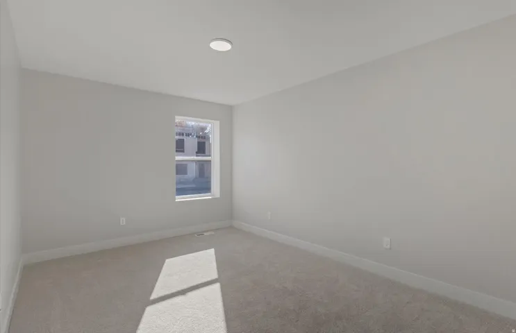 Recessed ceiling light, neutral wall tones, single window, and carpeted flooring