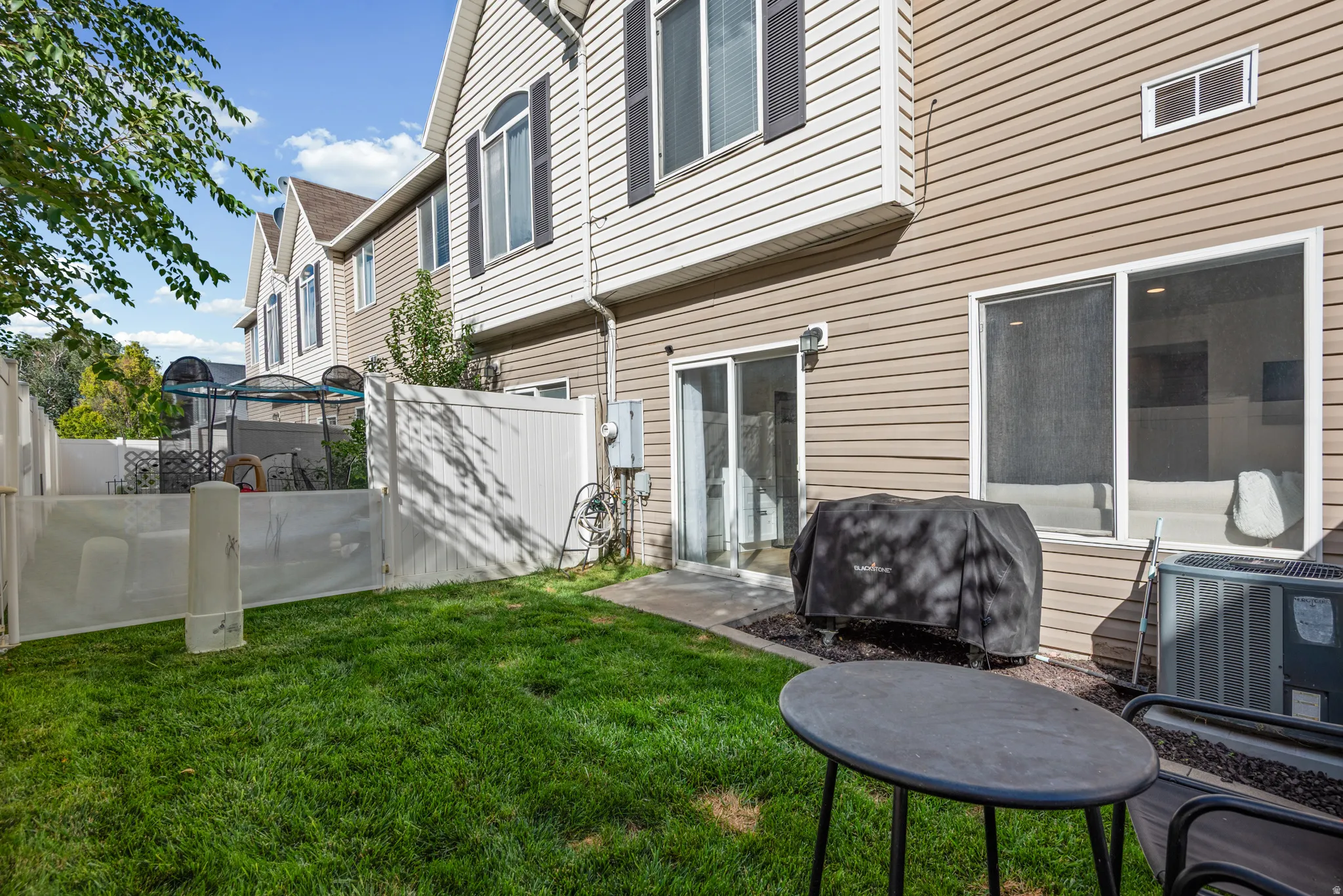 Private fenced backyard with a patio area and direct access to the interior via a sliding glass door