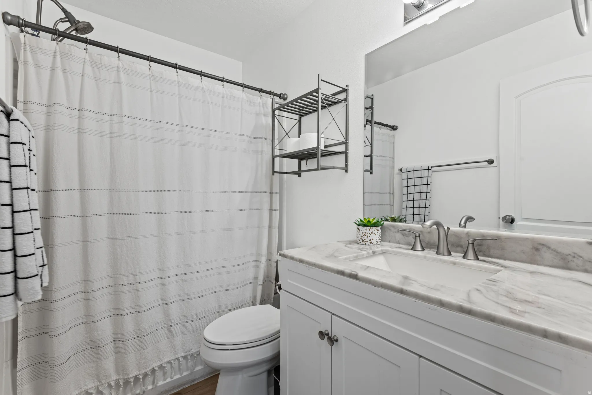 White vanity with undermount sink, brushed nickel faucet, and integrated countertop