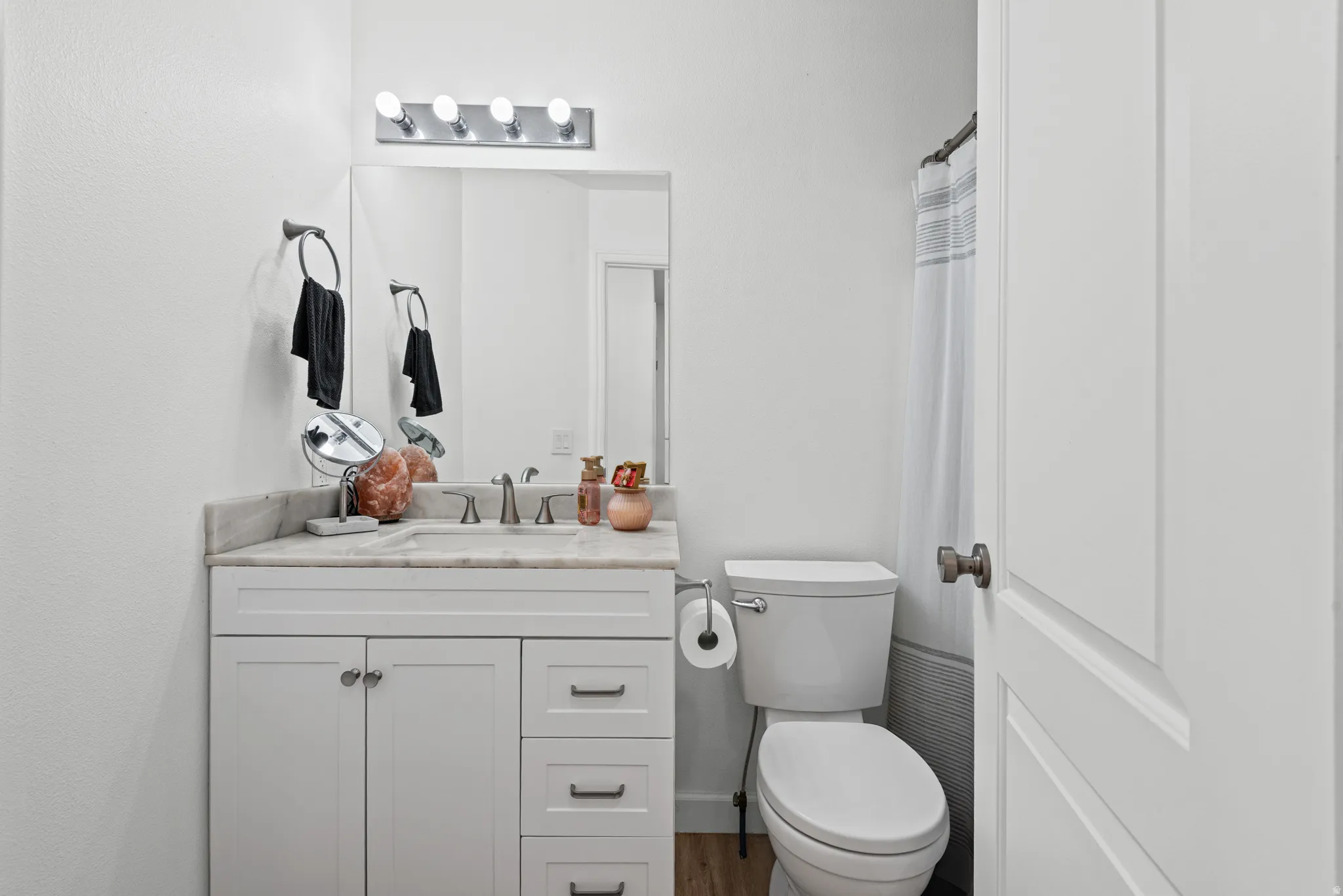 Vanity with a light-toned countertop, white cabinetry, and a single basin