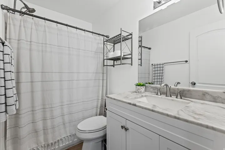 White vanity with undermount sink, brushed nickel faucet, and integrated countertop