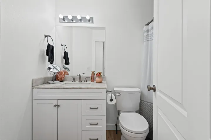 Vanity with a light-toned countertop, white cabinetry, and a single basin