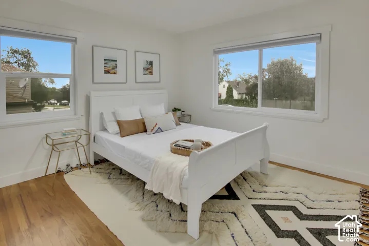 Hardwood flooring, white walls, and multiple windows with white trim