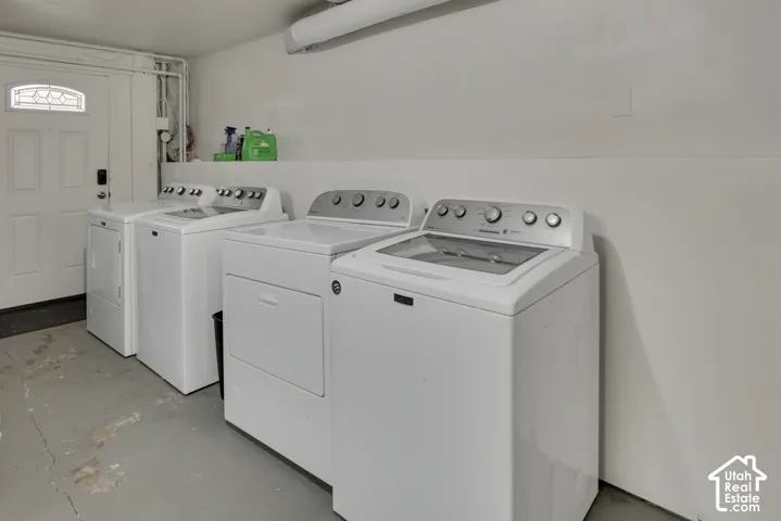 Laundry area featuring a paneled door with a decorative glass insert, a painted concrete floor, and white walls