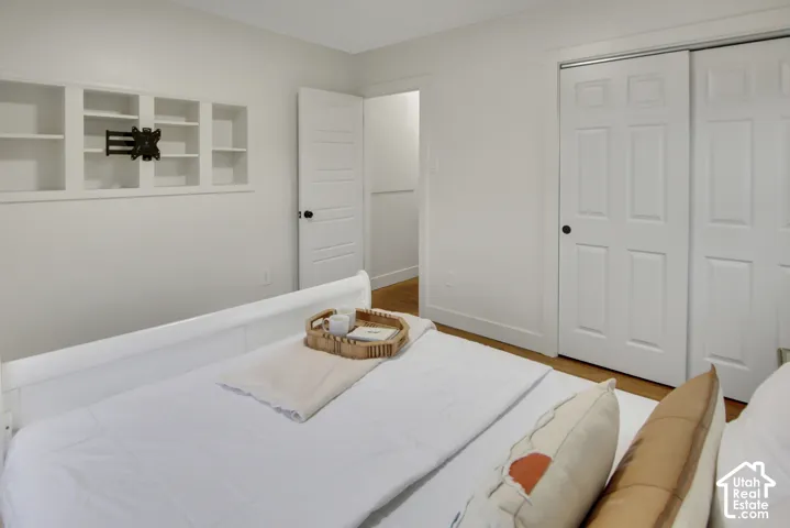 Integrated wall shelving, clean white walls, wood-finish flooring, white paneled doors, and a built-in wall mount