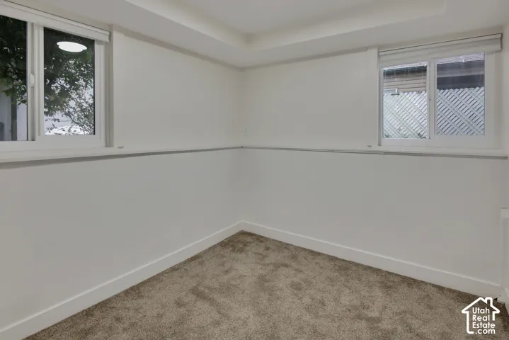 Recessed ceiling lighting, white walls, two windows, wall-to-wall carpeting, and white baseboards
