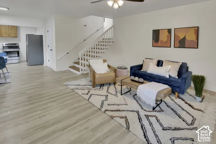 Light wood-finish flooring, white painted walls, and a staircase with white risers and wood treads