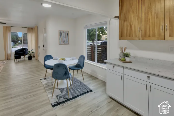 Light wood-finish flooring throughout, white base cabinets, and a light-toned countertop