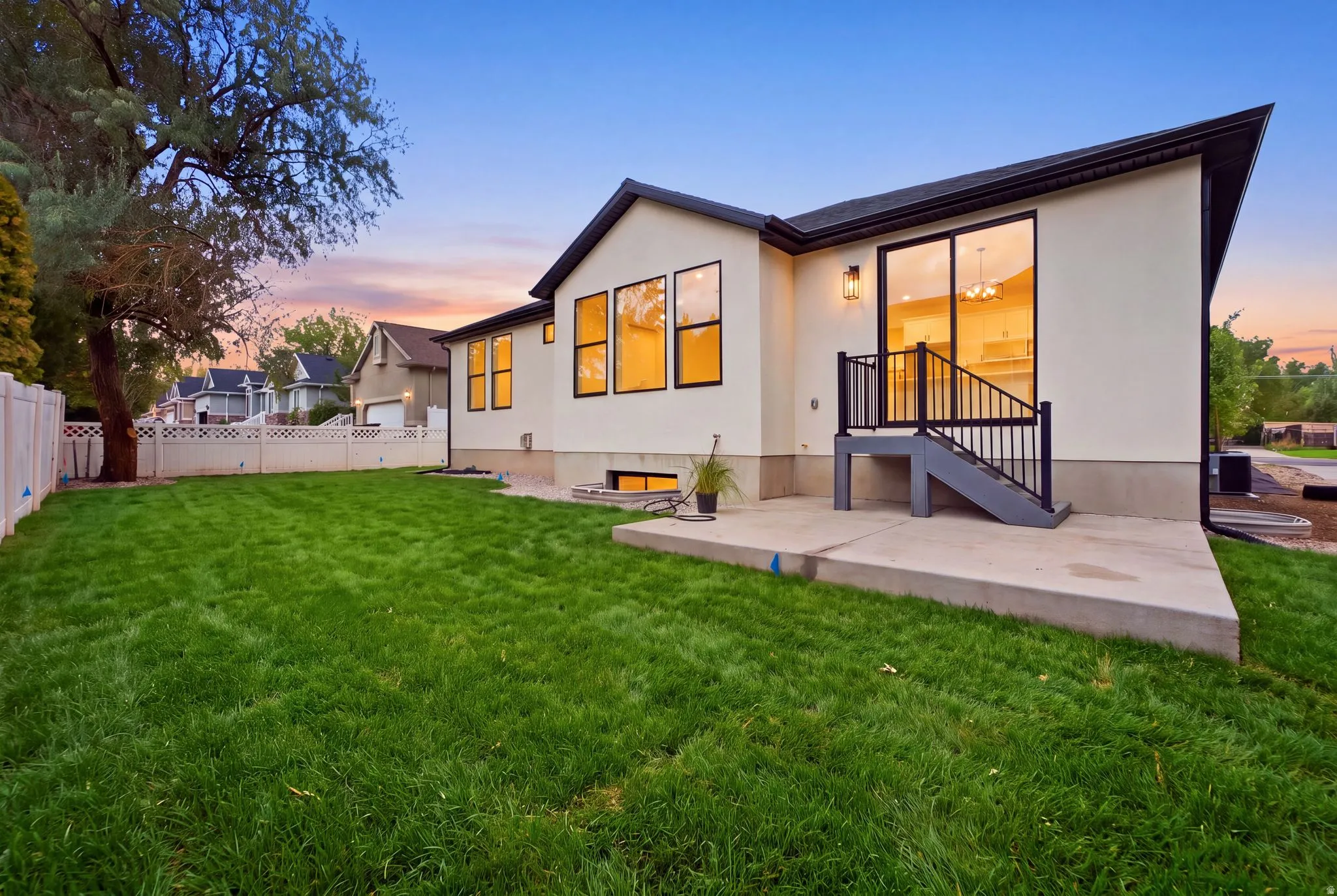 Expansive grassy lawn with a concrete patio and direct access via sliding glass doors