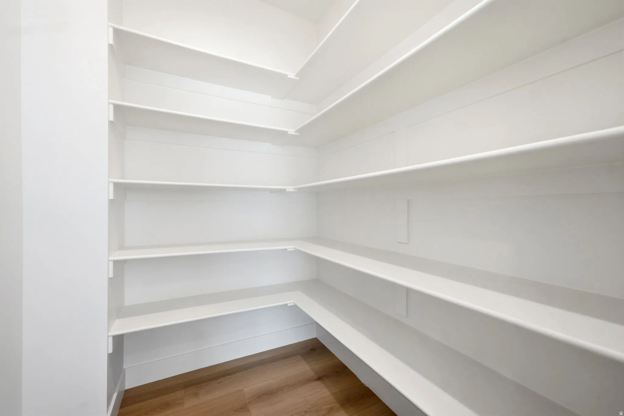 Built-in white shelving, wood-finish flooring