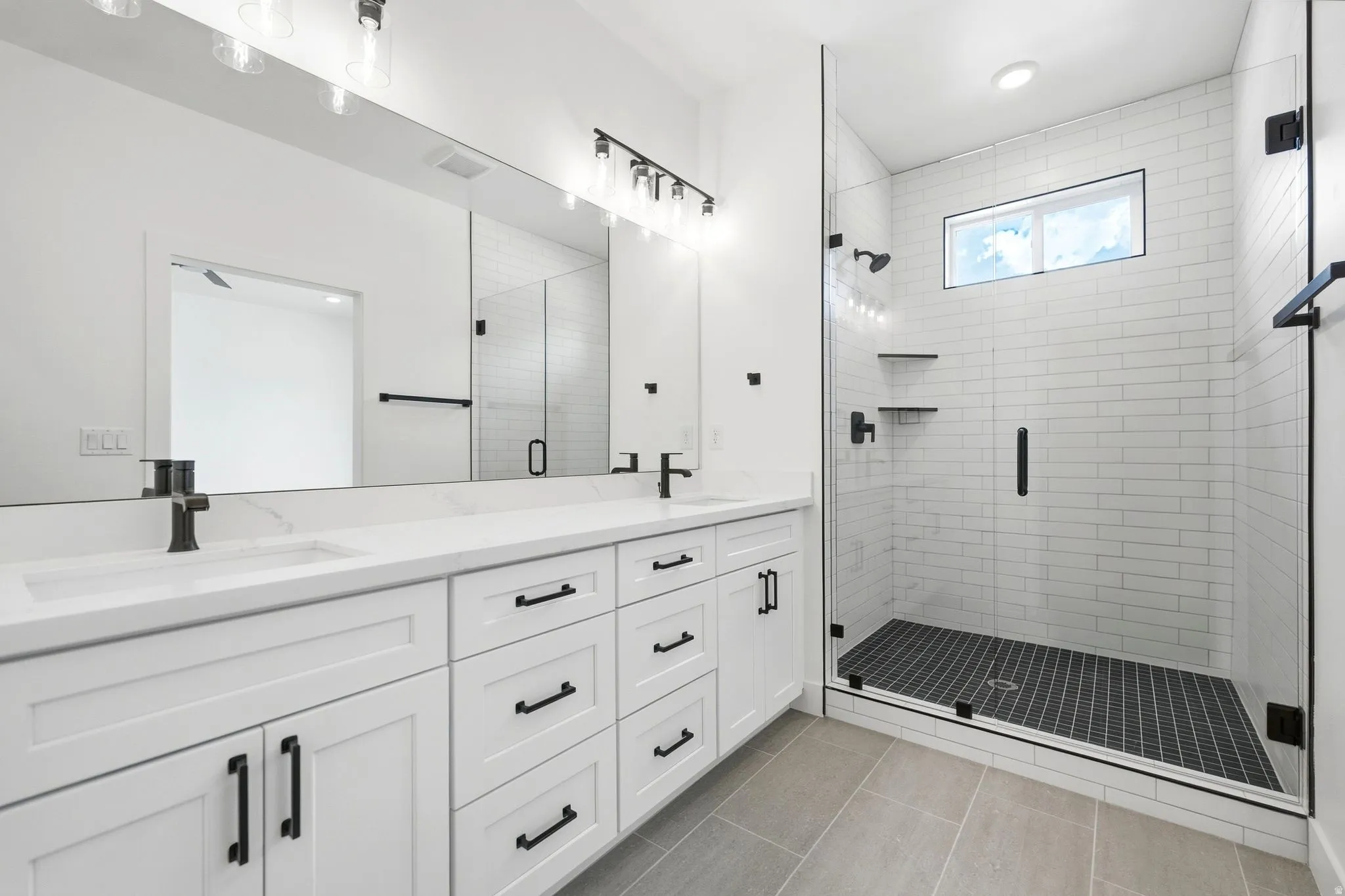 Dual vanity with white cabinetry, matte black hardware, and integrated sinks