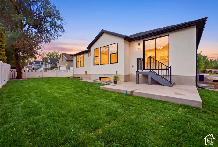 Expansive grassy lawn with a concrete patio and direct access via sliding glass doors