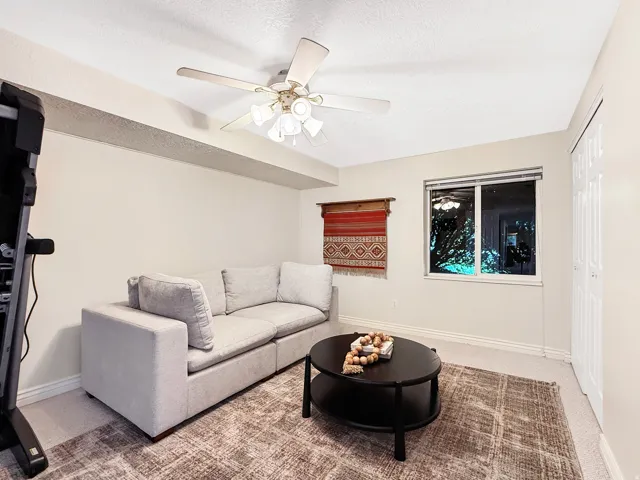 Recessed window, ceiling fan with light fixture, light-colored carpeting, white baseboards, and white bi-fold closet doors