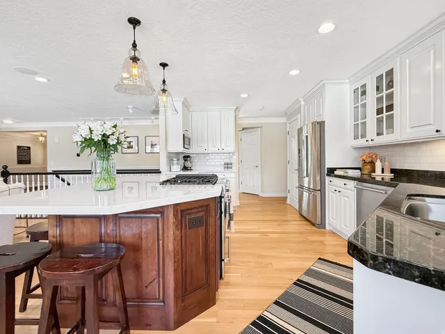 Kitchen featuring hardwood flooring, white cabinetry, recessed lighting, and a kitchen island with pendant lighting