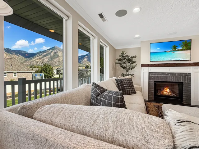 Living area featuring a brick fireplace with a wood mantle, recessed lighting, and large windows with mountain scenery