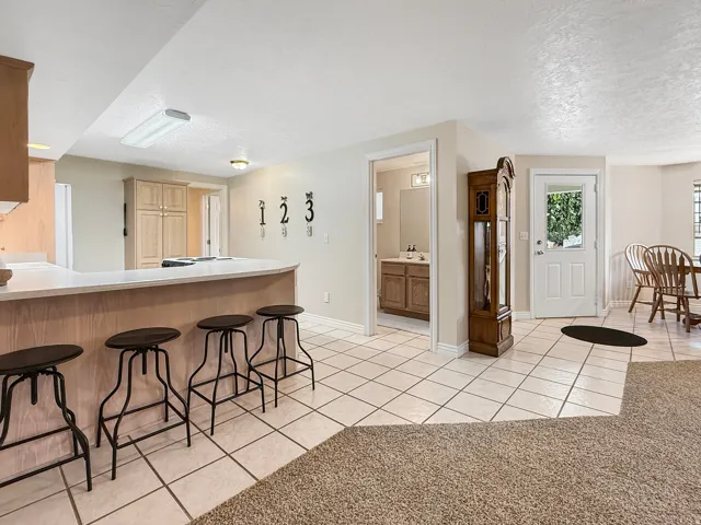 Breakfast bar with a light countertop, wood-finish base, and integrated overhead lighting
