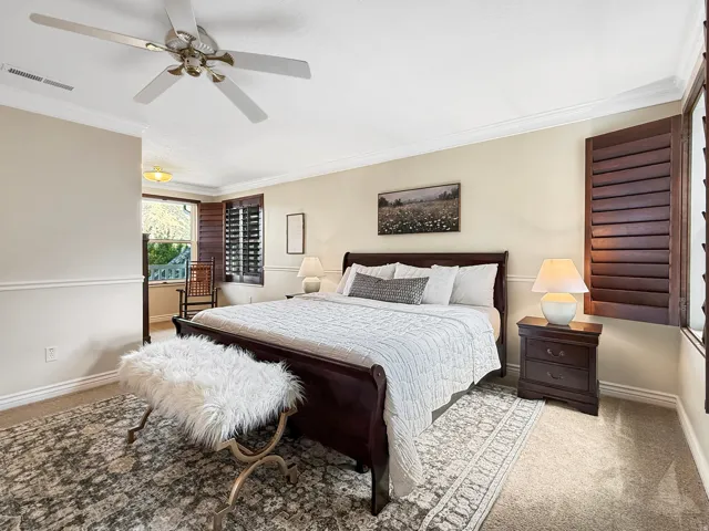 Recessed lighting, crown molding, and a ceiling fan enhance the space