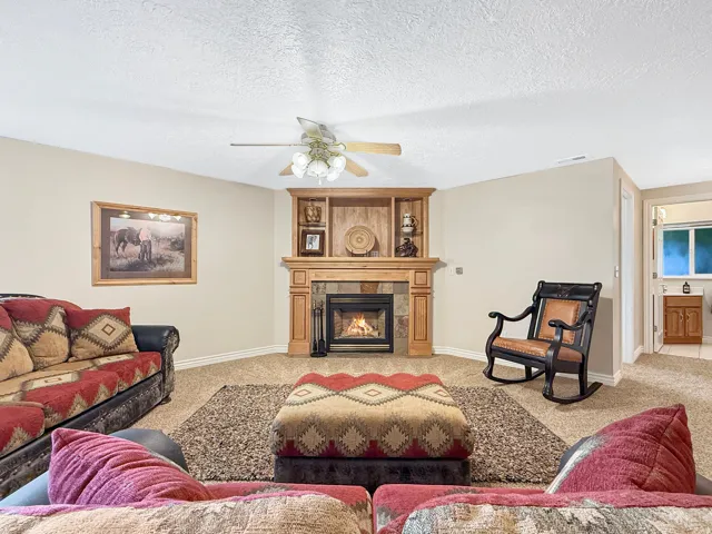 Built-in gas fireplace with stone surround and wood mantle, recessed shelving, and overhead lighting