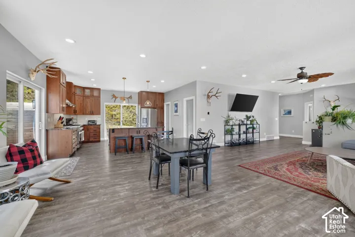 Expansive open-concept living area featuring wood-finish flooring, recessed lighting, and a ceiling fan