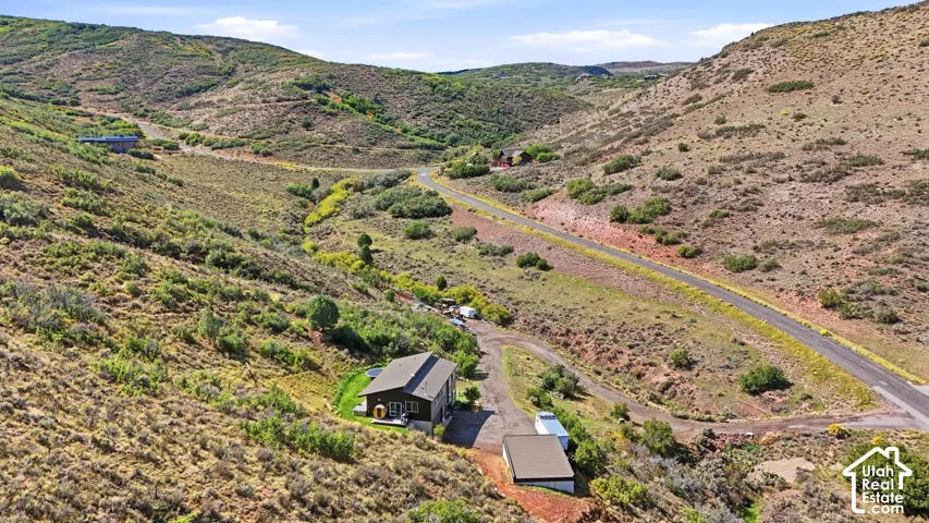Expansive mountain landscape with a residence featuring a dark-toned exterior