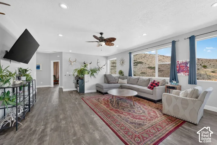 Spacious living area featuring wood-finish flooring, recessed lighting, and a ceiling fan
