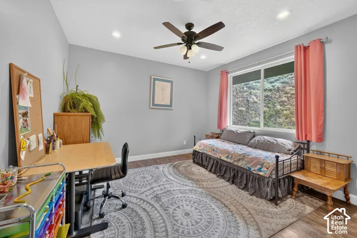Recessed lighting, wood-finish flooring, and a ceiling fan with integrated lighting