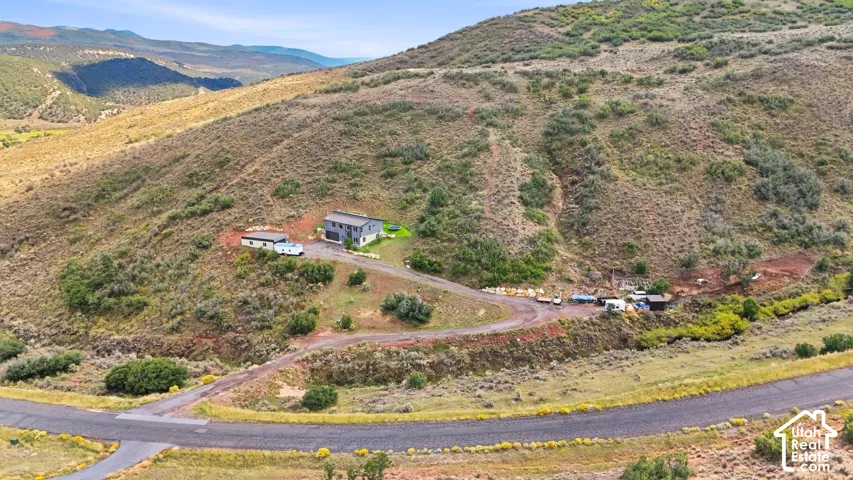 Hillsides featuring natural vegetation and a two-story residence