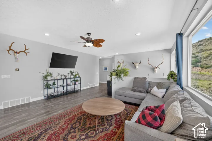 Spacious living area featuring wood-finish flooring, recessed lighting, and a ceiling fan