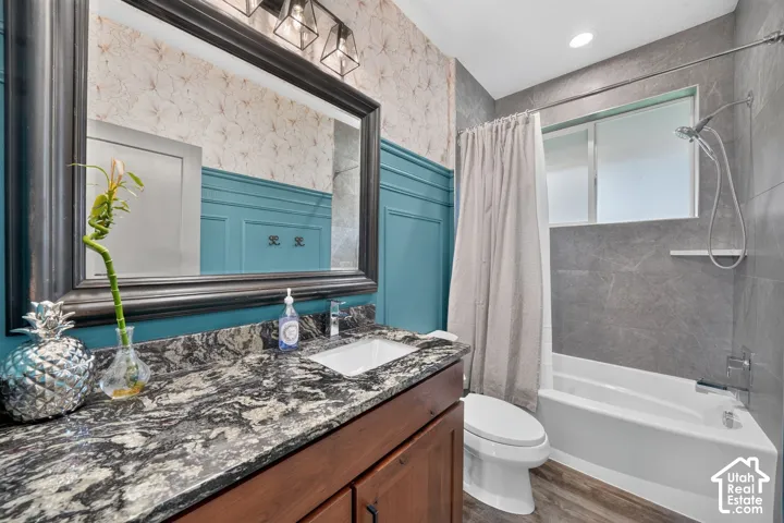Vanity with a rectangular undermount sink, dark-toned cabinetry, and a patterned countertop