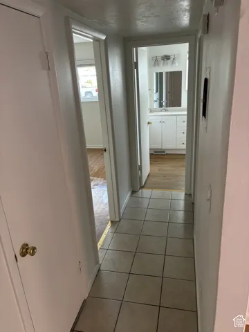 Hallway featuring square tile flooring