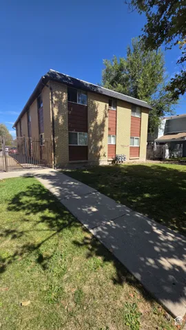 Brick exterior with contrasting panels, multiple windows, and a paved walkway
