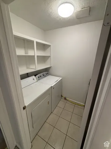 Laundry area with tile flooring and built-in shelving