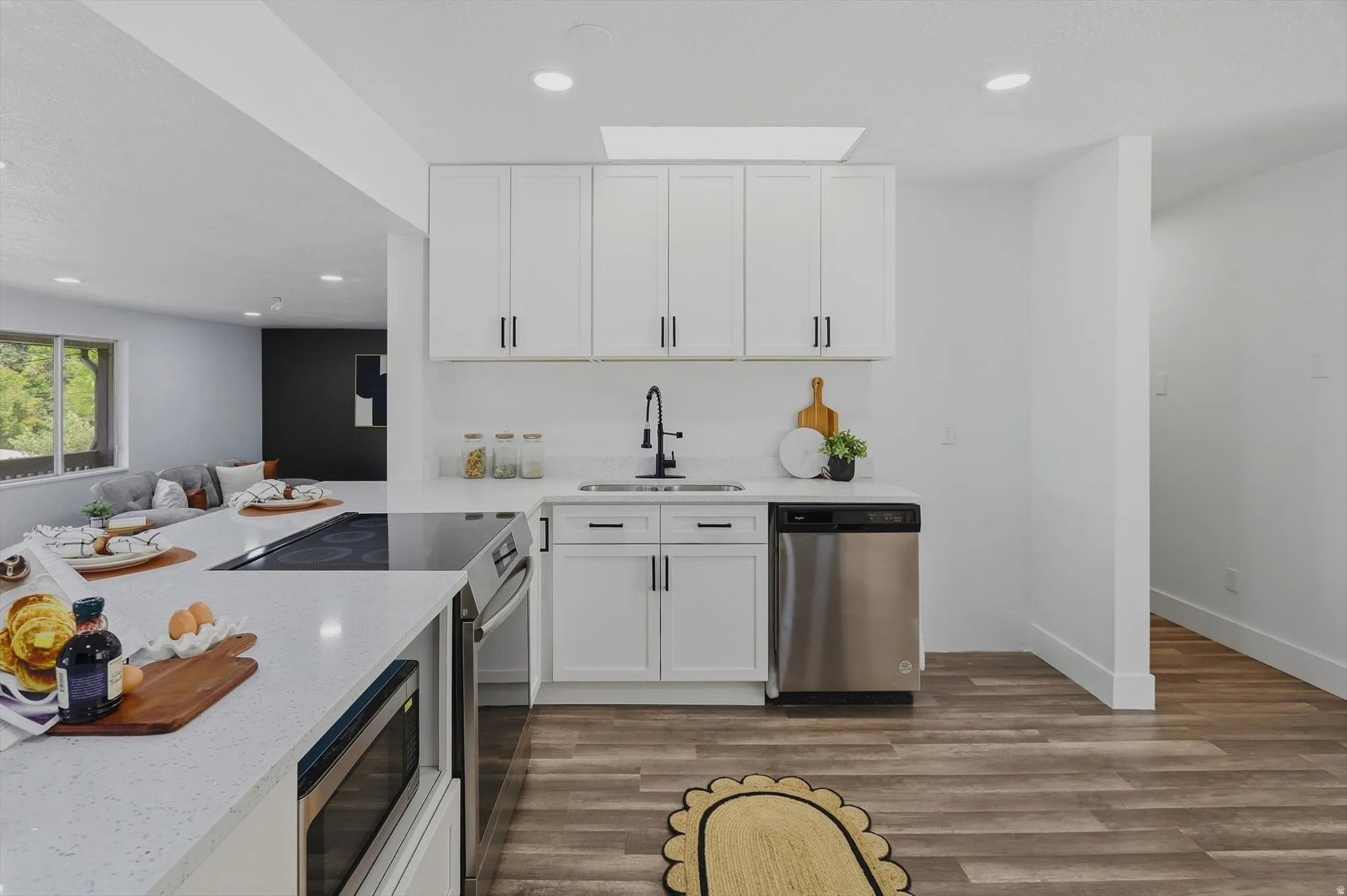 Kitchen featuring an integrated cooktop, stainless steel appliances, recessed lighting, and wood-finish flooring