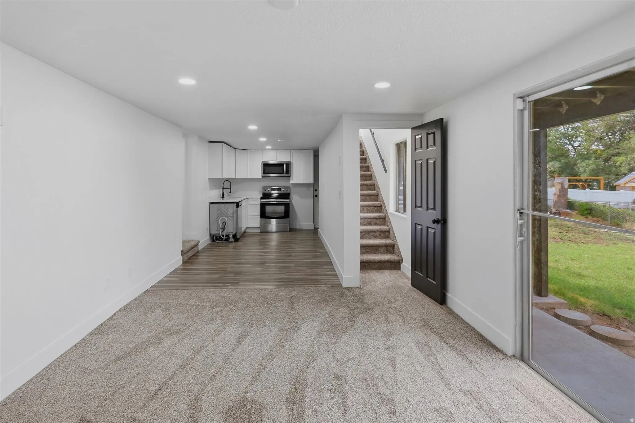 Kitchenette with white cabinetry and stainless steel appliances