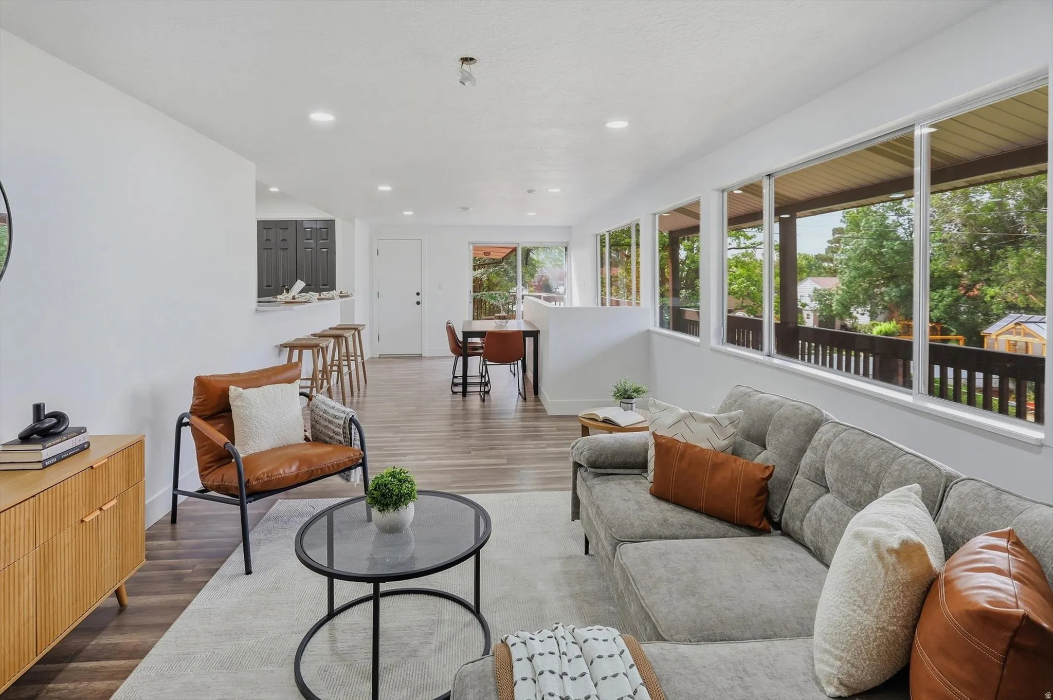 Open-concept living space with recessed lighting, wood-finish flooring, and expansive windows