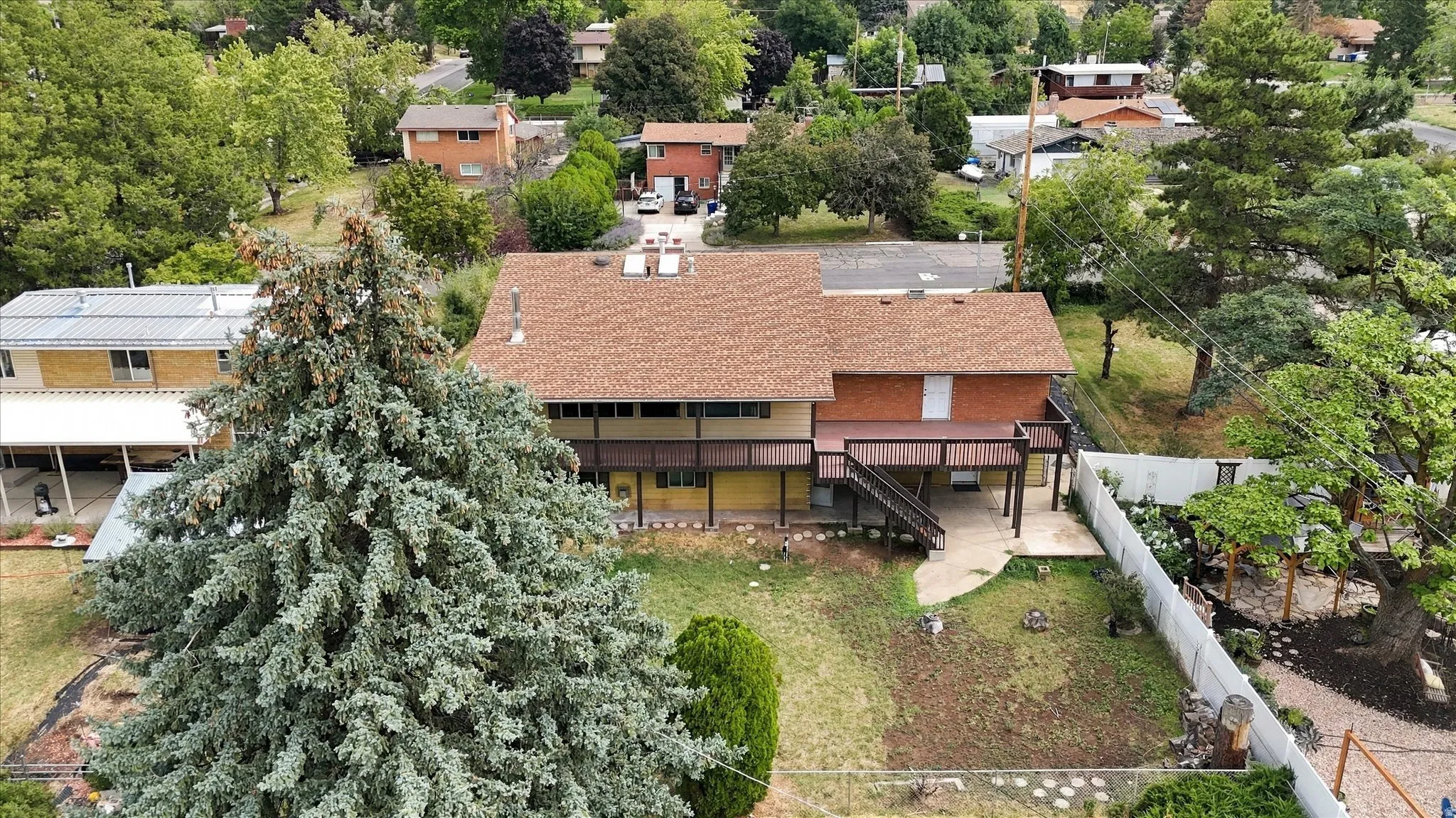 Two-story property with a shingle roof, a rear deck, and an expansive backyard
