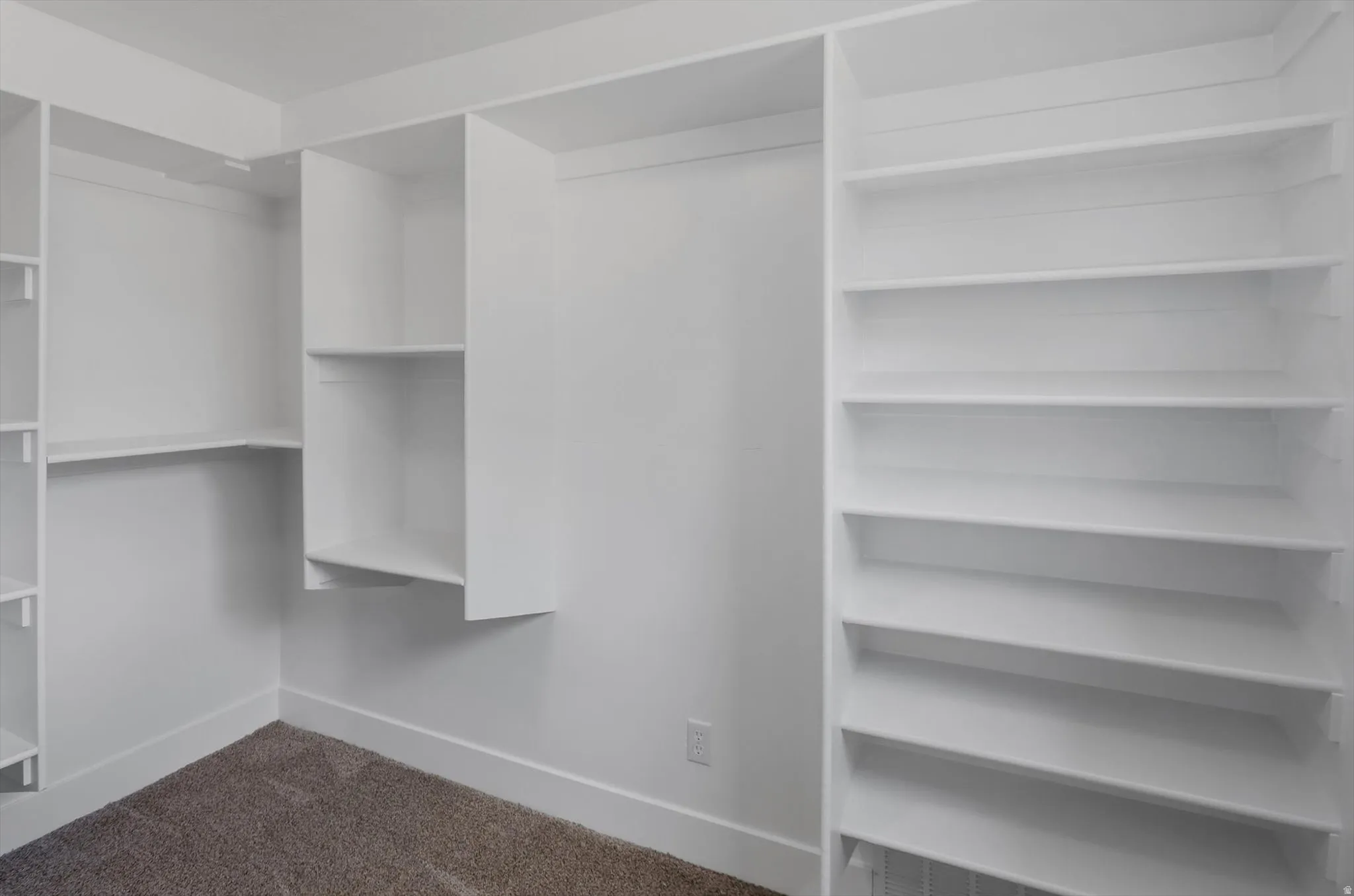 Custom closet organization system with multiple shelving units and hanging rods