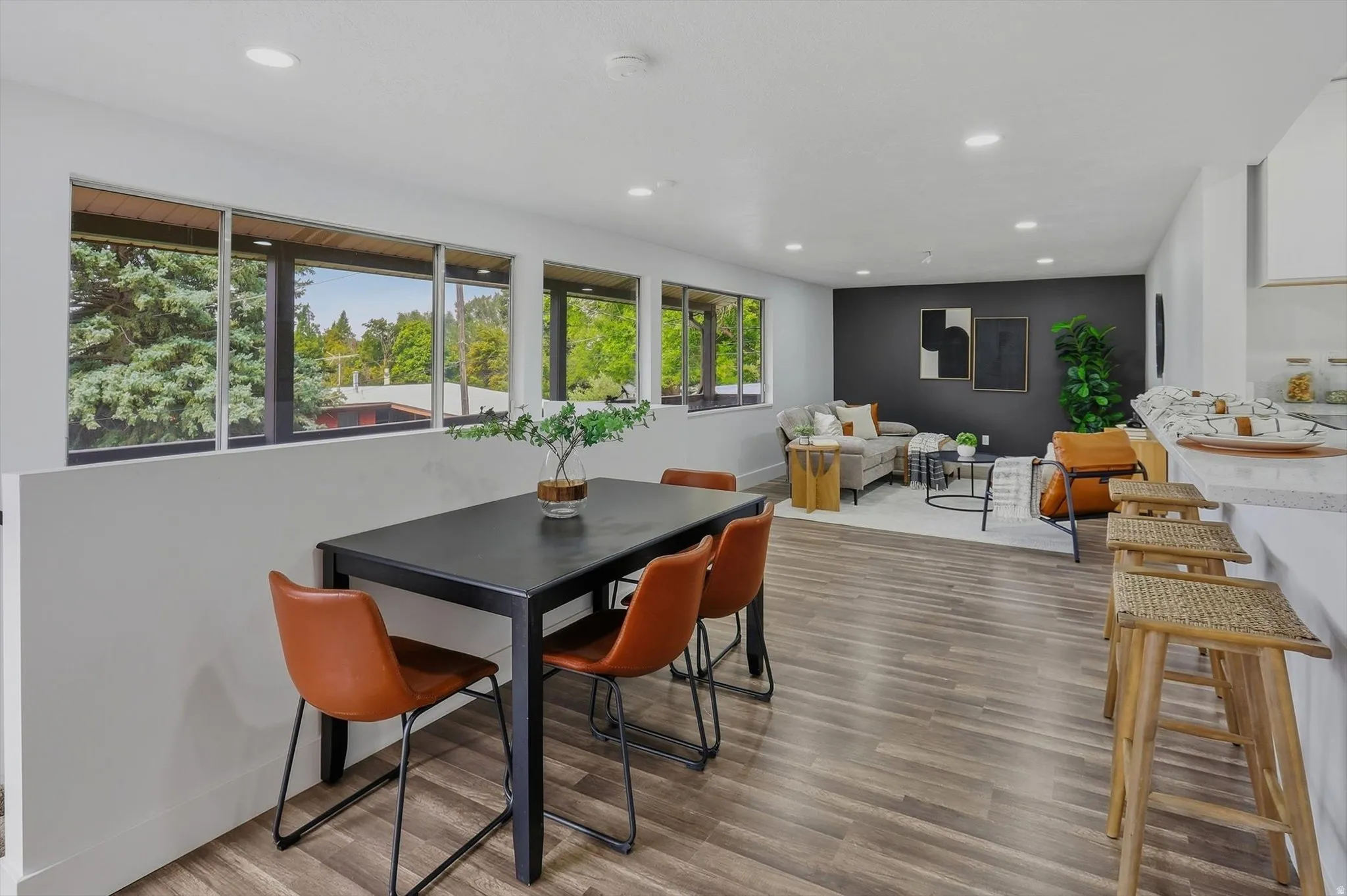 Wood-finish flooring throughout, recessed lighting, and a kitchen island with stone countertops
